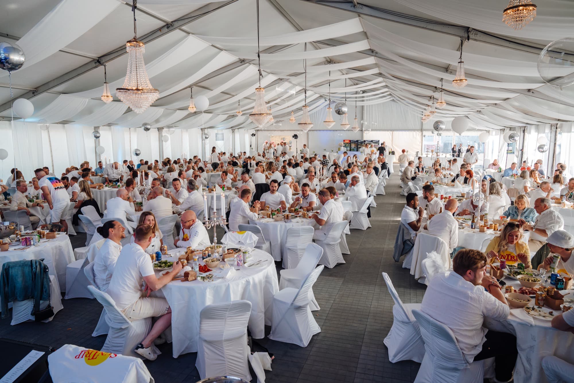 Middag och gäster i vit tältmiljö under Brandt White Party.